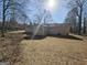 Expansive backyard view showcasing the home's siding and roofline, set against a backdrop of trees and foliage at 245 Kim Trl, Stockbridge, GA 30281