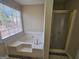 Bathroom features a shower with glass doors and a large soaking tub by a window at 245 Kim Trail, Stockbridge, GA 30281