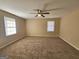 Bedroom featuring neutral colored walls, carpeted flooring, a ceiling fan and two large windows at 245 Kim Trl, Stockbridge, GA 30281