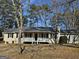 Inviting single-story house featuring a covered front porch and classic black shutters, set in a leafy neighborhood at 245 Kim Trail, Stockbridge, GA 30281