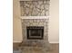 Close-up of a rustic stone fireplace with a white mantel, creating a warm and inviting focal point in the living room at 245 Kim Trl, Stockbridge, GA 30281