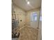 Laundry room with tile flooring, water heater, storage shelving, and a white entry door at 245 Kim Trail, Stockbridge, GA 30281