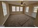 Living room featuring neutral carpet, multiple windows, and a ceiling fan at 245 Kim Trl, Stockbridge, GA 30281