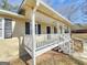 Close-up of a covered porch with white railings and black door, providing a welcoming entrance to the residence at 245 Kim Trl, Stockbridge, GA 30281