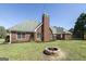 The backyard features a brick home, a cozy patio, and a stone fire pit perfect for outdoor gatherings at 1000 Maria Dr, Mcdonough, GA 30253