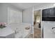 Bathroom featuring a large tub, tile surround, and a window, offering a relaxing space to unwind at 1000 Maria Dr, Mcdonough, GA 30253