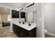 A bathroom with a double vanity with black cabinets and white countertops, a mirror and two entry-way doors at 1000 Maria Dr, Mcdonough, GA 30253
