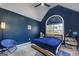 Cozy bedroom featuring blue accent wall, large window, and unique decor at 1000 Maria Dr, Mcdonough, GA 30253
