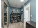 Walk-in closet with shelving for shoes and accessories with turquoise colored walls at 1000 Maria Dr, Mcdonough, GA 30253