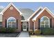 Charming brick home featuring arched windows, black shutters and a well-maintained landscaped yard at 1000 Maria Dr, Mcdonough, GA 30253