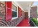 Inviting front porch with red flooring, decorative shutters, and classic white columns at 3216 Pheasant Dr, Decatur, GA 30034