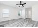 Bright bedroom with ceiling fan, gray wood-look floors, and natural light from two windows at 3201 Azteca Way, Dacula, GA 30019