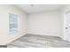 Clean and bright bedroom featuring gray wood-look flooring and a window at 3121 Azteca Way, Dacula, GA 30019