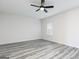 Well lit bedroom showcasing gray wood-look floors and modern ceiling fan at 3121 Azteca Way, Dacula, GA 30019