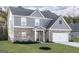 Charming exterior showcasing a brick and gray facade, green lawn, and a two-car garage at 3754 Saddle Bag Ct, Dacula, GA 30019