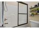 Bathroom shower and toilet with towel rack and shelving at 3403 Bill Gardner Pkwy, Locust Grove, GA 30248