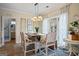 Charming dining area features a modern chandelier, bright windows, and views into the adjacent bathroom at 3403 Bill Gardner Pkwy, Locust Grove, GA 30248