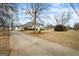 Long driveway leading to a beautiful house with a well-kept lawn and mature trees at 3403 Bill Gardner Pkwy, Locust Grove, GA 30248
