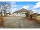 Spacious home featuring a large driveway and a beautifully landscaped yard with mature trees at 3403 Bill Gardner Pkwy, Locust Grove, GA 30248