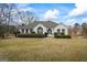 Charming white brick home with a well-manicured lawn and a bright blue front door at 3403 Bill Gardner Pkwy, Locust Grove, GA 30248