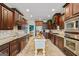 Spacious kitchen featuring dark wood cabinetry, stainless steel appliances, granite countertops, and a center island at 3403 Bill Gardner Pkwy, Locust Grove, GA 30248