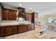 Well-appointed kitchen with dark wood cabinets, stainless appliances, and a view of the light-filled dining area at 3403 Bill Gardner Pkwy, Locust Grove, GA 30248
