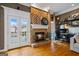 Warm living room boasts stone fireplace, hardwood flooring, natural light, and workstation at 3403 Bill Gardner Pkwy, Locust Grove, GA 30248