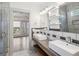 Bright bathroom featuring double sinks, open shelving, and a glass door to the shower at 560 John Wesley Dobbs Ne Ave, Atlanta, GA 30312