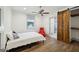 Cozy bedroom featuring a ceiling fan, a window and sliding barn door to the closet at 560 John Wesley Dobbs Ne Ave, Atlanta, GA 30312