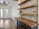 Dining area with exposed brick wall, wooden shelves, wood countertop, cabinets and wine fridge at 560 John Wesley Dobbs Ne Ave, Atlanta, GA 30312
