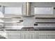 Modern kitchen with stainless appliances, gas range and hood, white cabinets and open shelving at 560 John Wesley Dobbs Ne Ave, Atlanta, GA 30312
