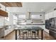 A modern kitchen with an island and breakfast bar, tiled backsplash, stainless appliances, and wood floors at 560 John Wesley Dobbs Ne Ave, Atlanta, GA 30312