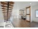 Open living room with wood floors, custom stairs, and wet bar with industrial-style sliding doors at 560 John Wesley Dobbs Ne Ave, Atlanta, GA 30312