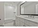 Elegant bathroom with a large mirror, white cabinets, and a combination tub and shower unit at 110 Warren Way, Fayetteville, GA 30215