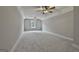 Vast bonus room with two ceiling fans, a window, and soft carpeting at 110 Warren Way, Fayetteville, GA 30215