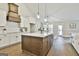 Open kitchen with custom cabinetry, stainless appliances, stone countertops, and pendant lighting at 110 Warren Way, Fayetteville, GA 30215