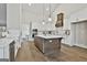Bright kitchen features white cabinets, a large island, stainless steel appliances, and hardwood floors at 110 Warren Way, Fayetteville, GA 30215