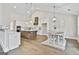 Bright kitchen and dining area with white cabinets, a large island, and modern light fixtures at 110 Warren Way, Fayetteville, GA 30215