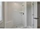Modern tiled shower features a built-in seat and stylish fixtures in a bright, well-lit bathroom at 110 Warren Way, Fayetteville, GA 30215