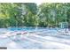 Community pool surrounded by lounge chairs, lifeguard, and mature trees for relaxing summer days at 4696 Dunover Cir, Dunwoody, GA 30360