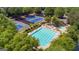 Aerial view of a community pool, tennis courts, and surrounding landscaping; offering an abundance of recreational activities at 6360 Brookline Ct, Cumming, GA 30040