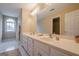Neutral bathroom featuring a double sink vanity, shower, and a large window at 6360 Brookline Ct, Cumming, GA 30040