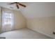 Bright bedroom featuring neutral carpet, angled ceilings, and a large window at 6360 Brookline Ct, Cumming, GA 30040
