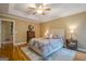 Inviting bedroom with hardwood floors, tray ceiling, and a comfortable queen-sized bed at 6360 Brookline Ct, Cumming, GA 30040