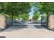 Community gated entrance with brick pillars and a tree lined drive to the clubhouse at 6360 Brookline Ct, Cumming, GA 30040
