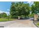 Community gated entrance with brick pillars and a tree lined drive to the clubhouse at 6360 Brookline Ct, Cumming, GA 30040