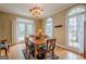 Traditional dining room featuring a chandelier, hardwood floors, and natural light from the large windows at 6360 Brookline Ct, Cumming, GA 30040
