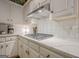 Modern kitchen featuring stainless steel hood vent, white cabinets, and sleek countertops at 6360 Brookline Ct, Cumming, GA 30040