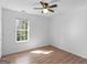Bedroom with modern ceiling fan, wood flooring, and natural light from the large window at 150 Grove Creek Dr, Locust Grove, GA 30248
