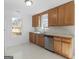 Well-lit kitchen with oak cabinets, stainless steel dishwasher, and views from two windows at 150 Grove Creek Dr, Locust Grove, GA 30248
